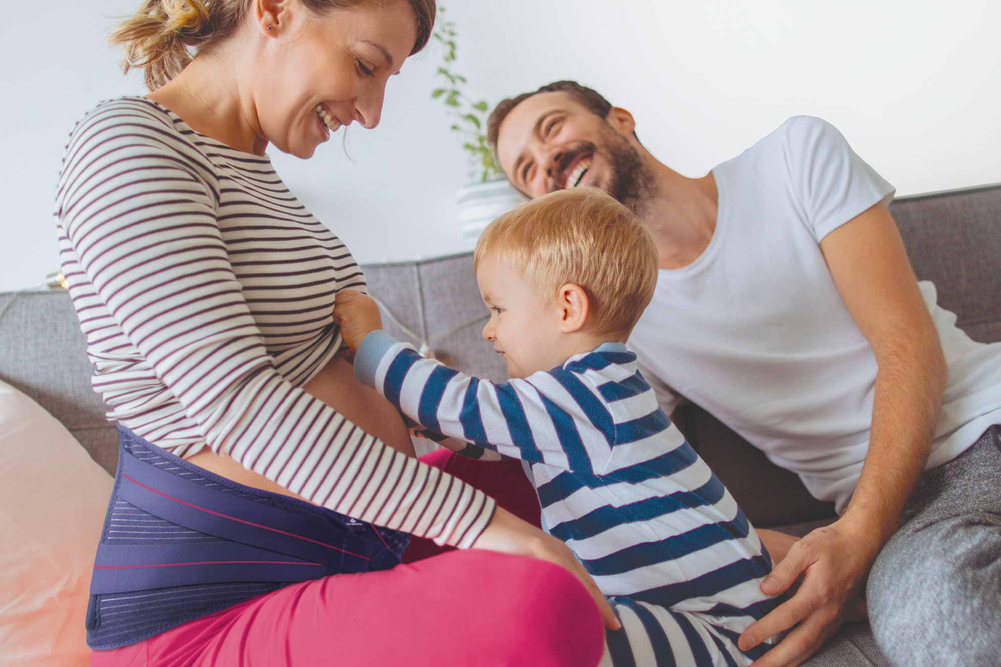 orliman maternity - famille heureuse avec bébé regardant ventre de maman avec une ceinture lombaire