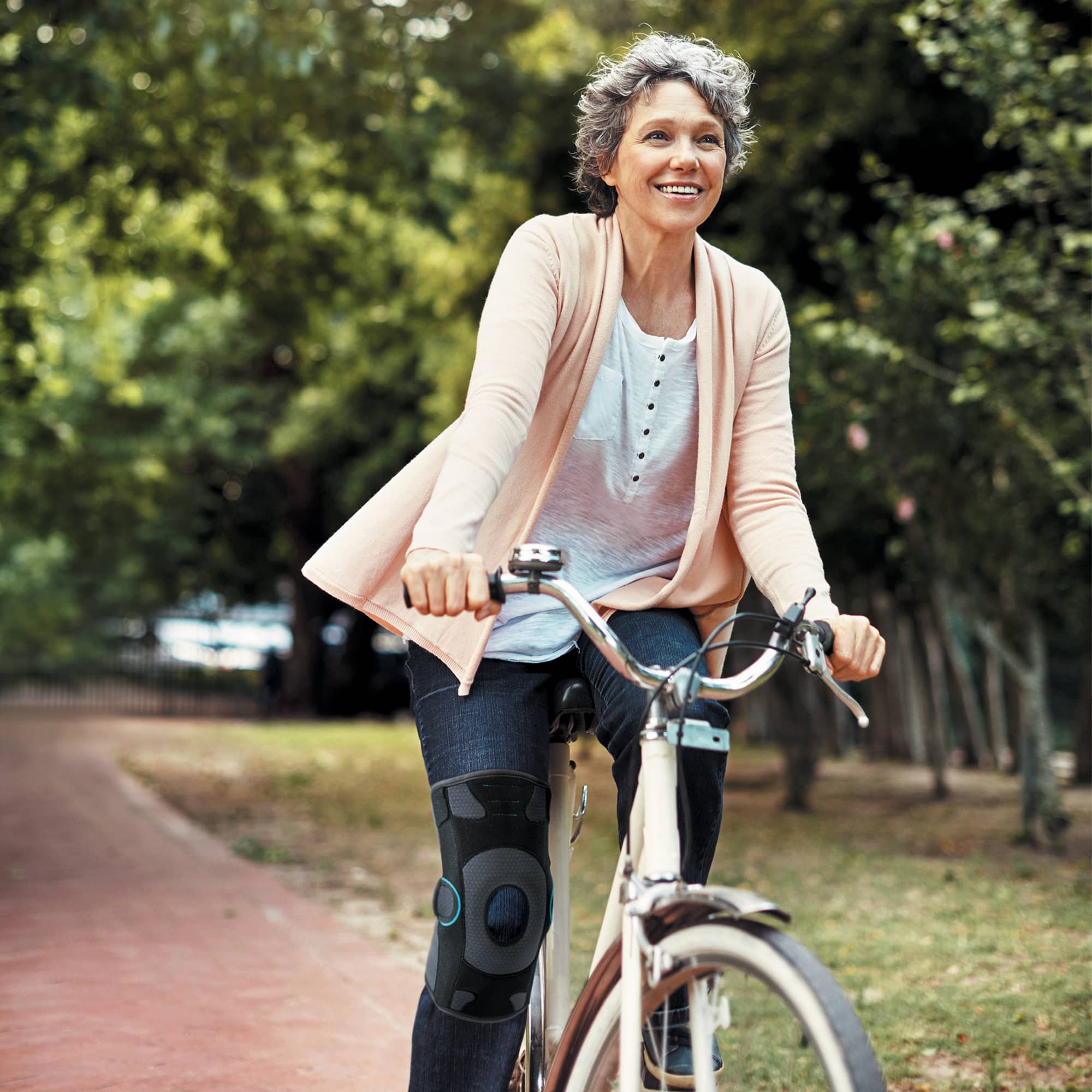 Femme à vélo avec une genouillère anti-gonarthrose