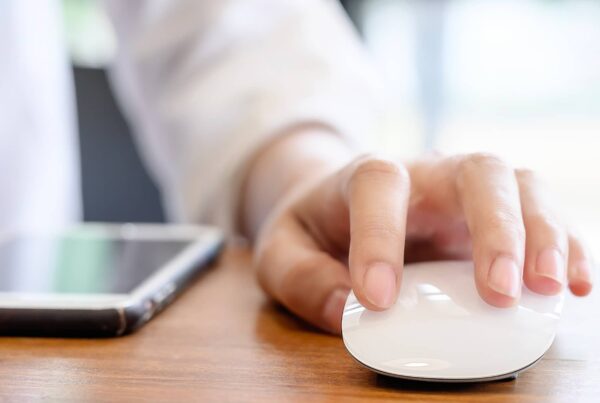 Gros plan d'une main de femme tenant une souris d'ordinateur