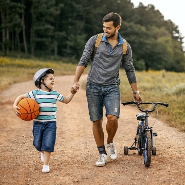 orliman-chevistrap-sit-1200 Homme en balade avec un enfant, souriant et portant la chevillère Chevistrap Orliman pour un maintien confortable en mouvement.