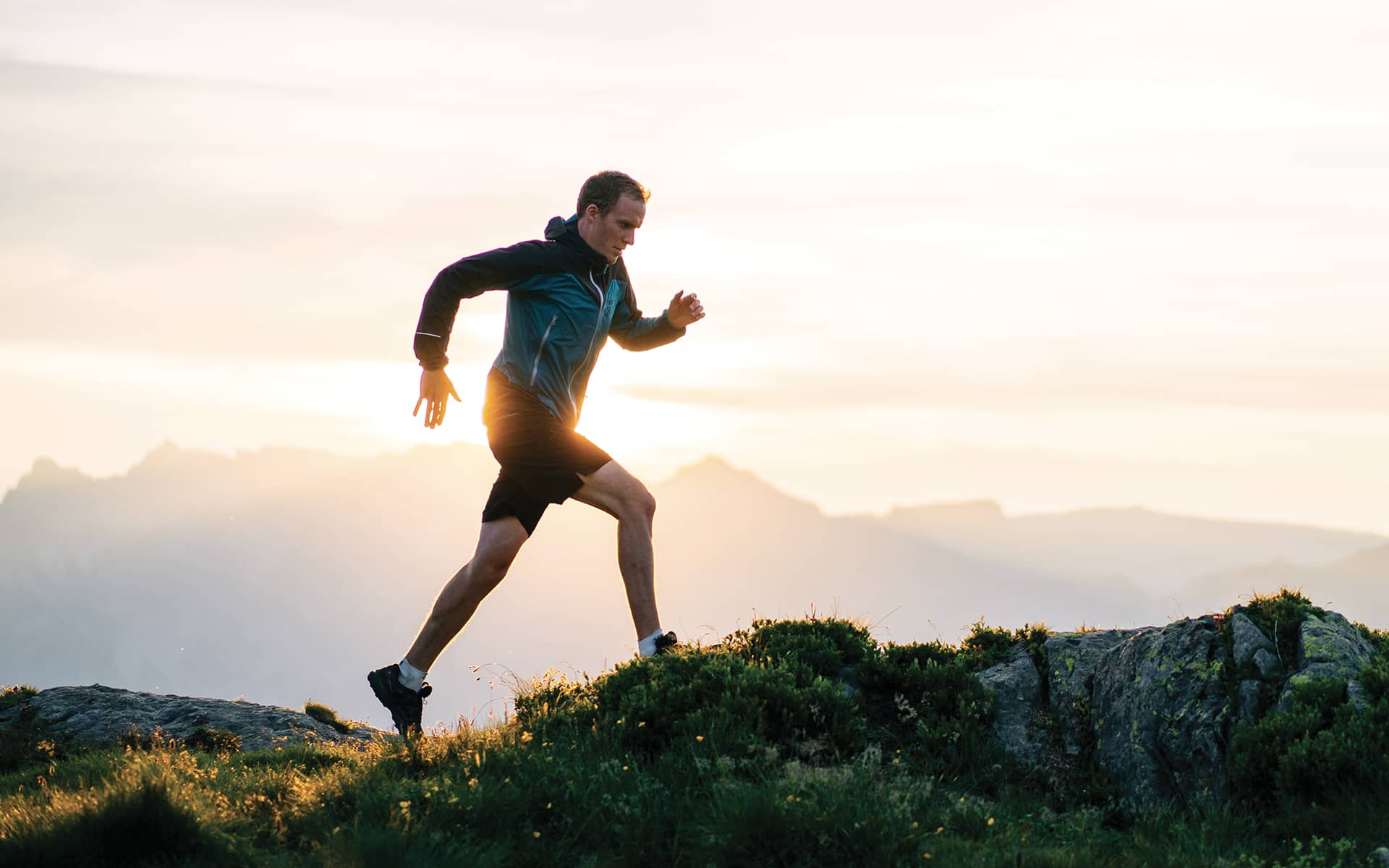 homme sportif faisant un jogging sur fond de paysage de montagne