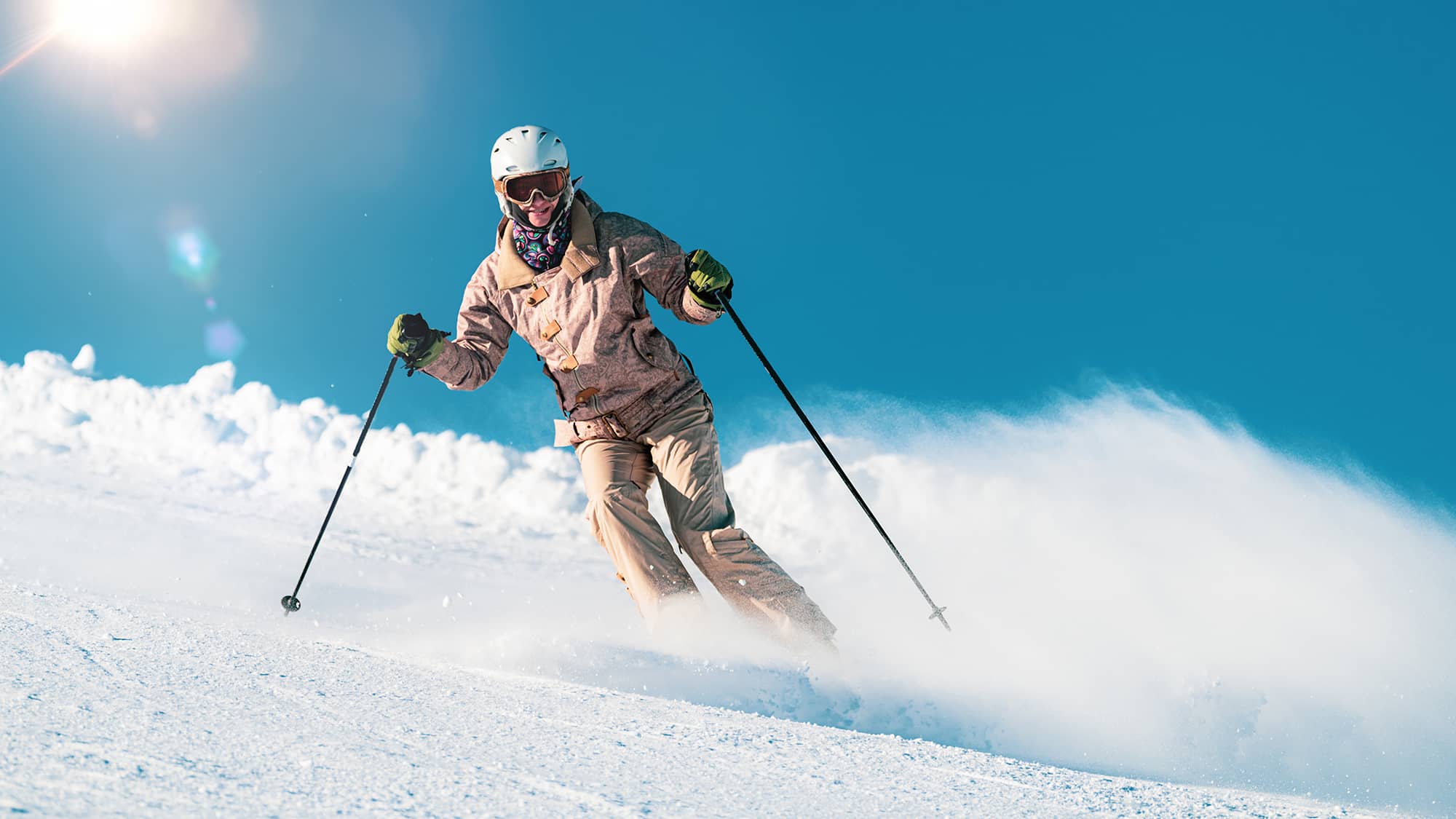 Femme à ski sur une piste de ski ensoleillée
