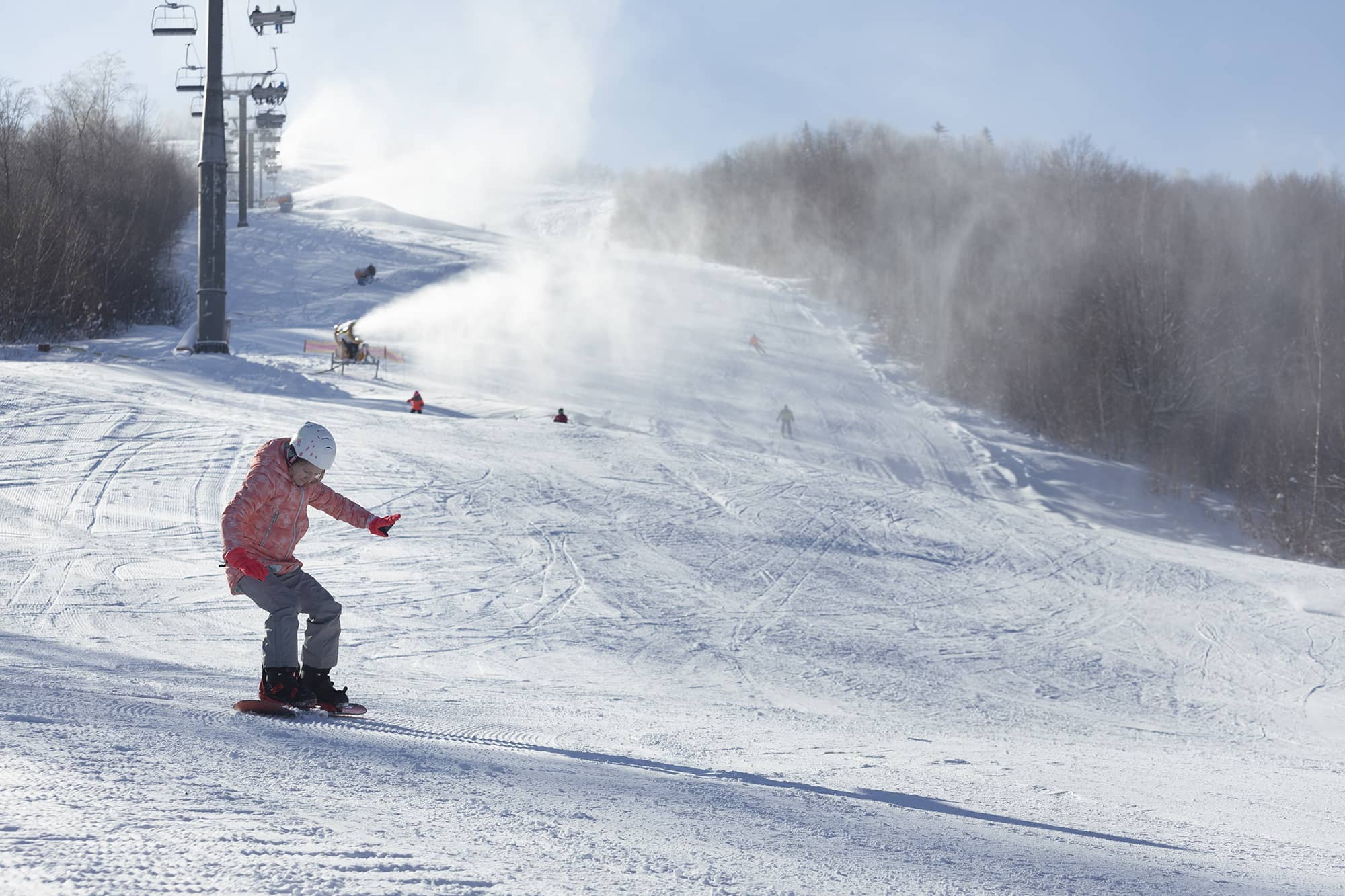 Adolescente en snowboard sur une piste de ski