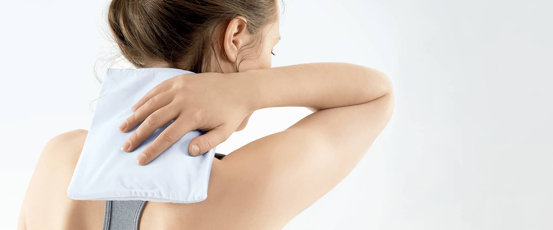 Application d’une compresse chaude pour soulager naturellement la cervicalgie.