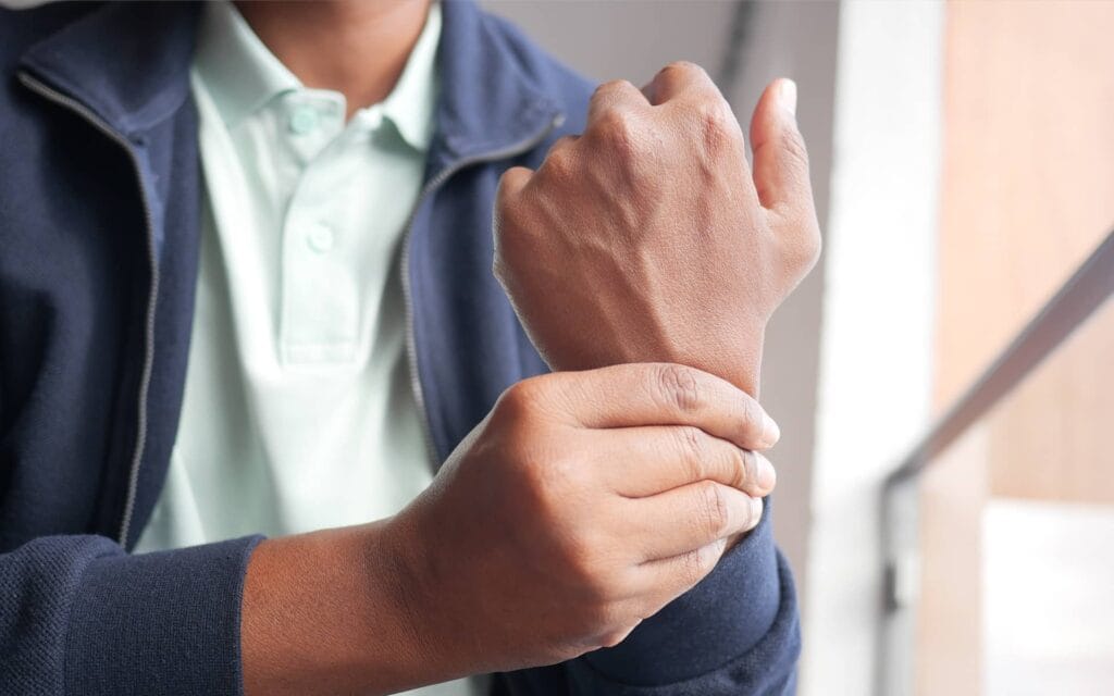 Homme se tenant le poignet à cause d’une tendinite de De Quervain provoquant une douleur au poignet