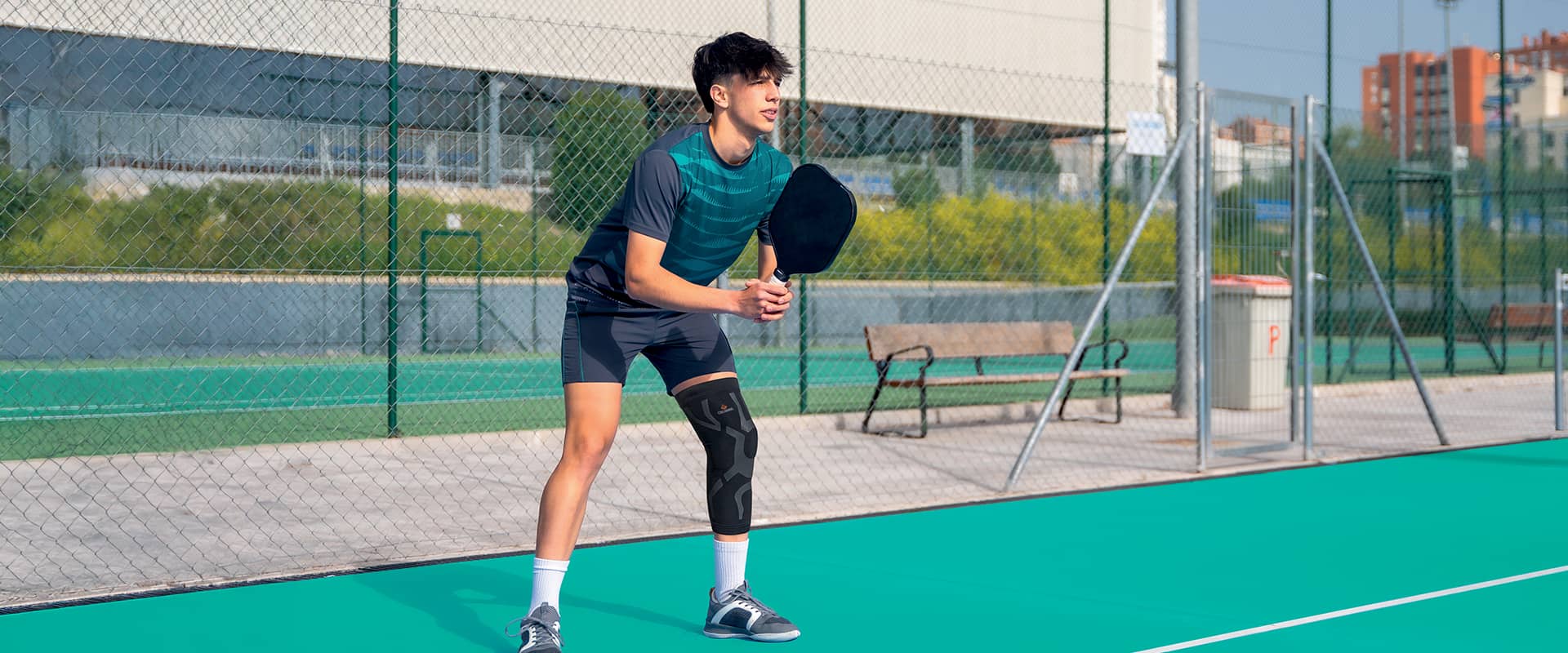Joueur de padel portant une genouillère de compression Skintape pour prévenir et protéger les blessures musculaires du genou