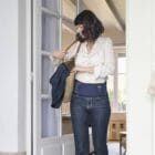 Femme debout se préparant à sortir de chez elle avec sa ceinture lombaire de thermothérapie Prim’Arthrose pour soulager les douleurs liées à l’arthrose lombaire débutante